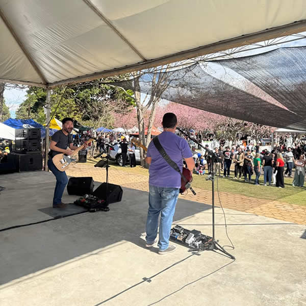 Apresentação musical ao vivo no palco sob a tenda principal da festa junina